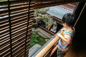 Child watches visitors meditate at the Shima Geisha House, Kanaz